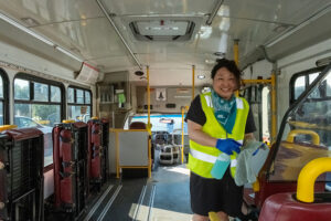 A volunteer in a reflective vest inside a paratransit b us.