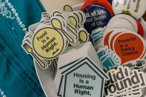 A close up of colorful stickers, including ones that read "Food is a human right" and "Housing is a human right."