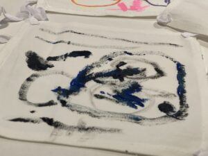 A close of colorful swirlying swatches of paint on a fabric square