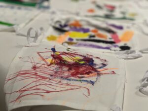 A close of colorful swirlying swatches of paint on a fabric square